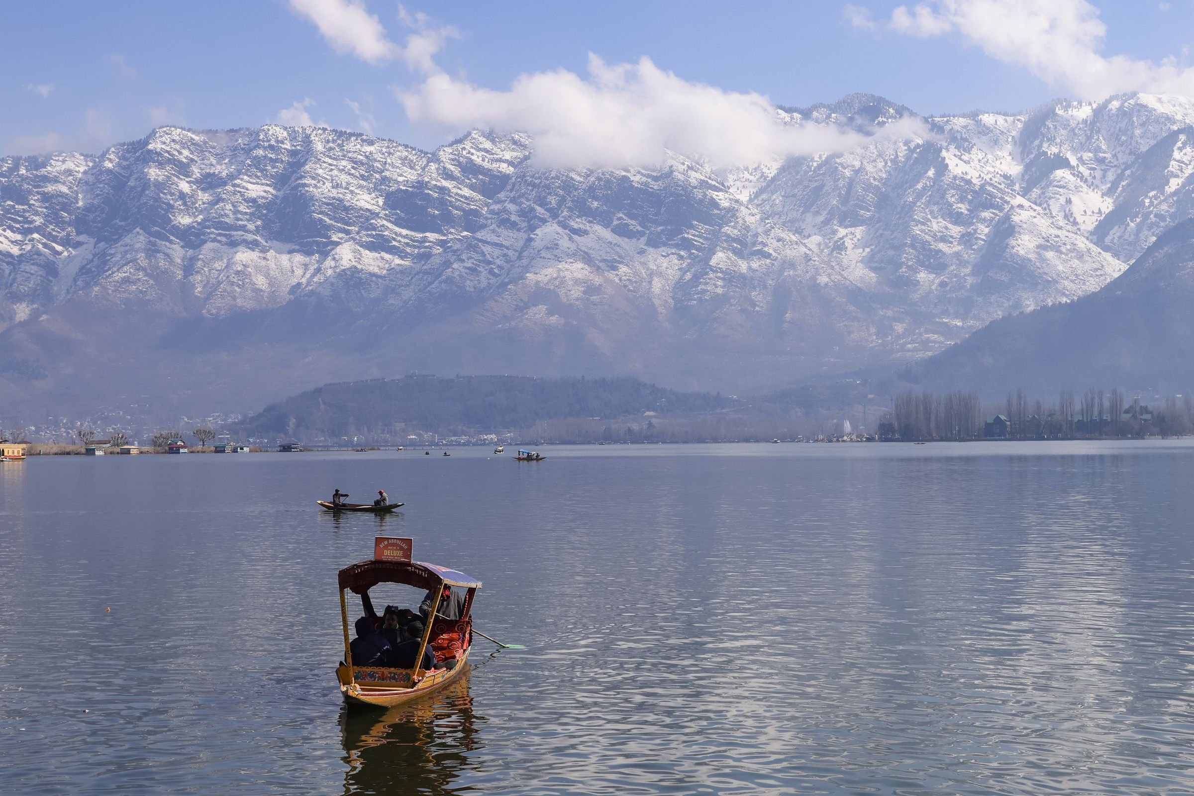 Shikara on Dal Lake below snow-capped mountains, Srinagar
